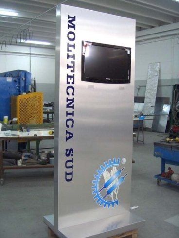 Un espositore in metallo con schermo montato e logo aziendale in un ambiente da officina.