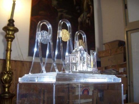 Scultura in vetro trasparente con archi e un edificio in miniatura su una base a specchio, per interni.