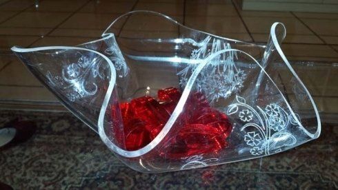 Ciotola in vetro trasparente con motivo floreale inciso, contenente caramelle rosse.