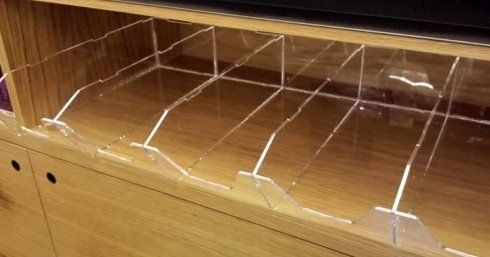 Contenitori in acrilico trasparente all'interno di un mobiletto in legno.