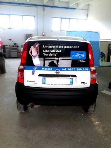 Vista posteriore di una Fiat Panda bianca con la pubblicità di