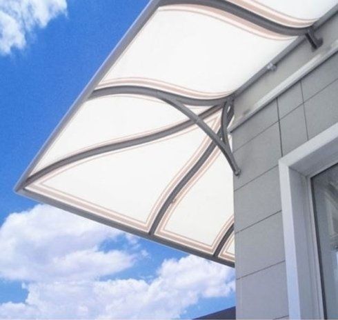 Tenda da sole bianca con cornice grigia curva sopra una finestra, contro un cielo azzurro.