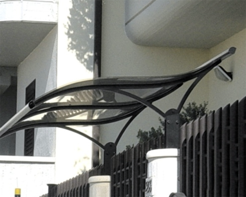 Tettoia in metallo nero e plastica trasparente sopra una recinzione.