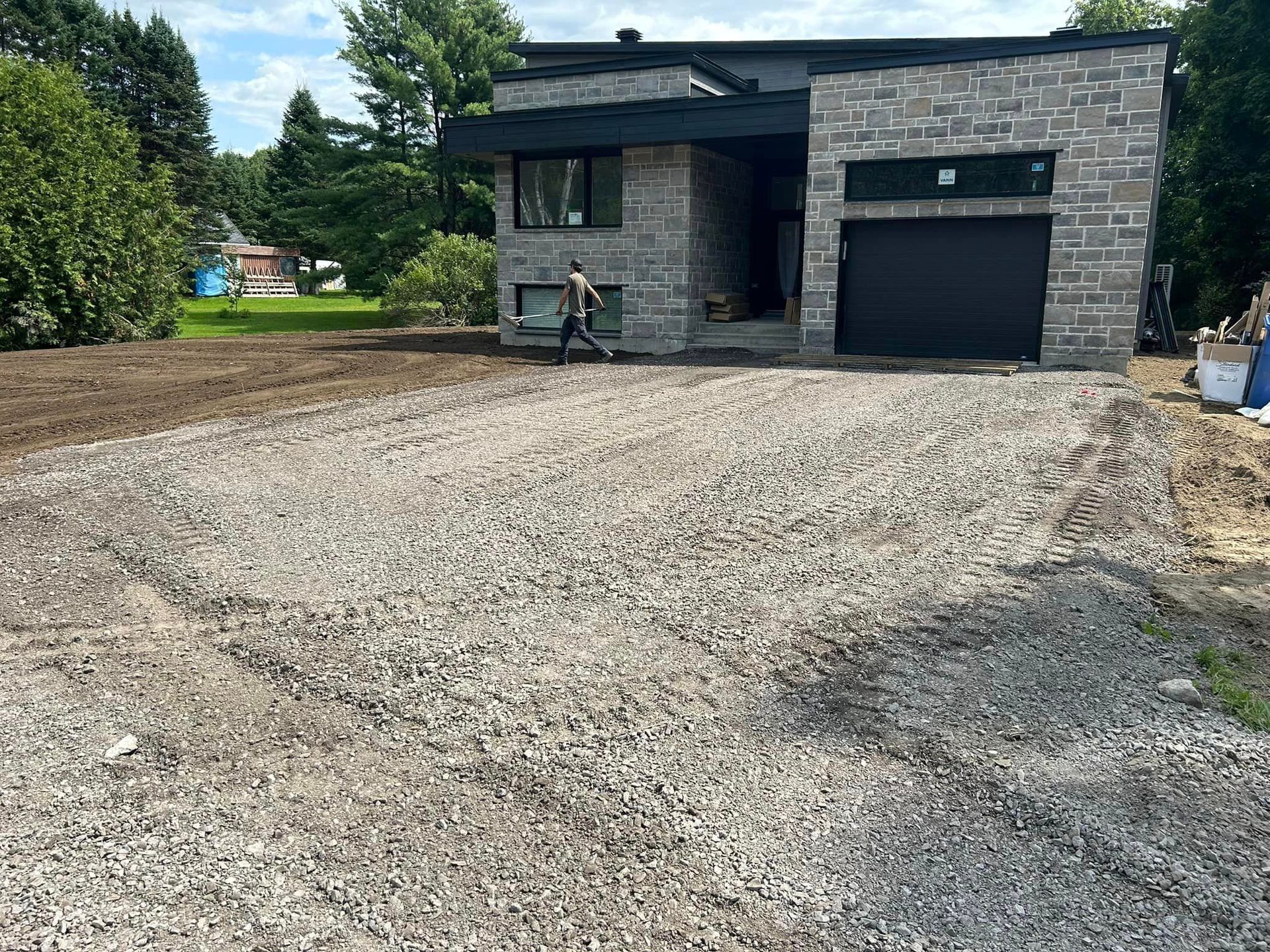 Une maison en brique avec une allée de gravier devant elle.