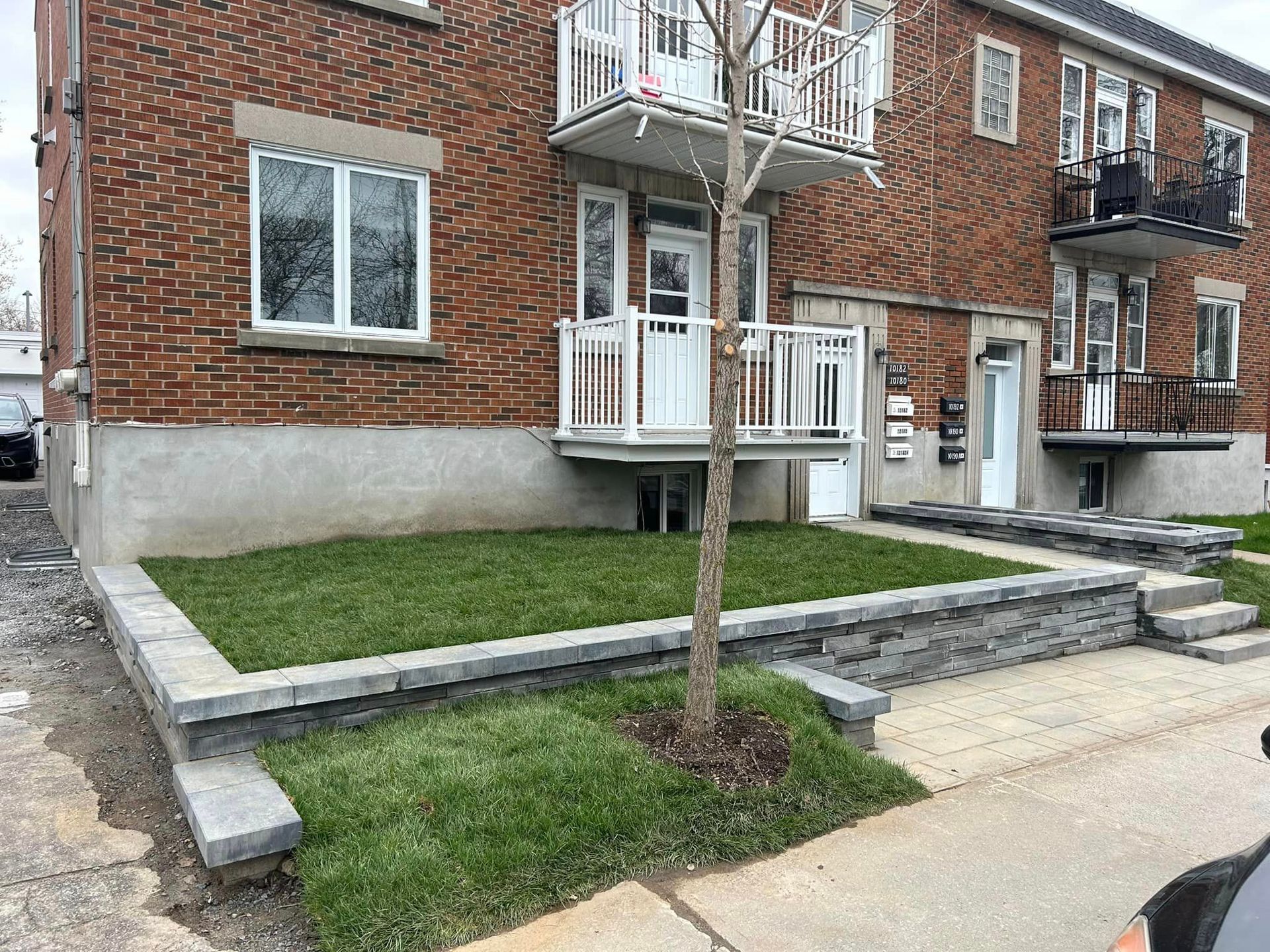 Un bâtiment en briques avec une pelouse verte luxuriante devant lui.