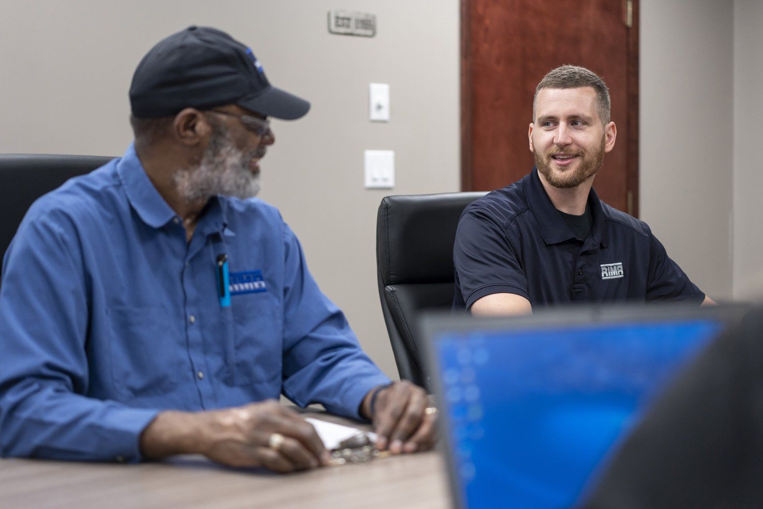 Two RIMA Manufacturing Company team members talking in a conference room