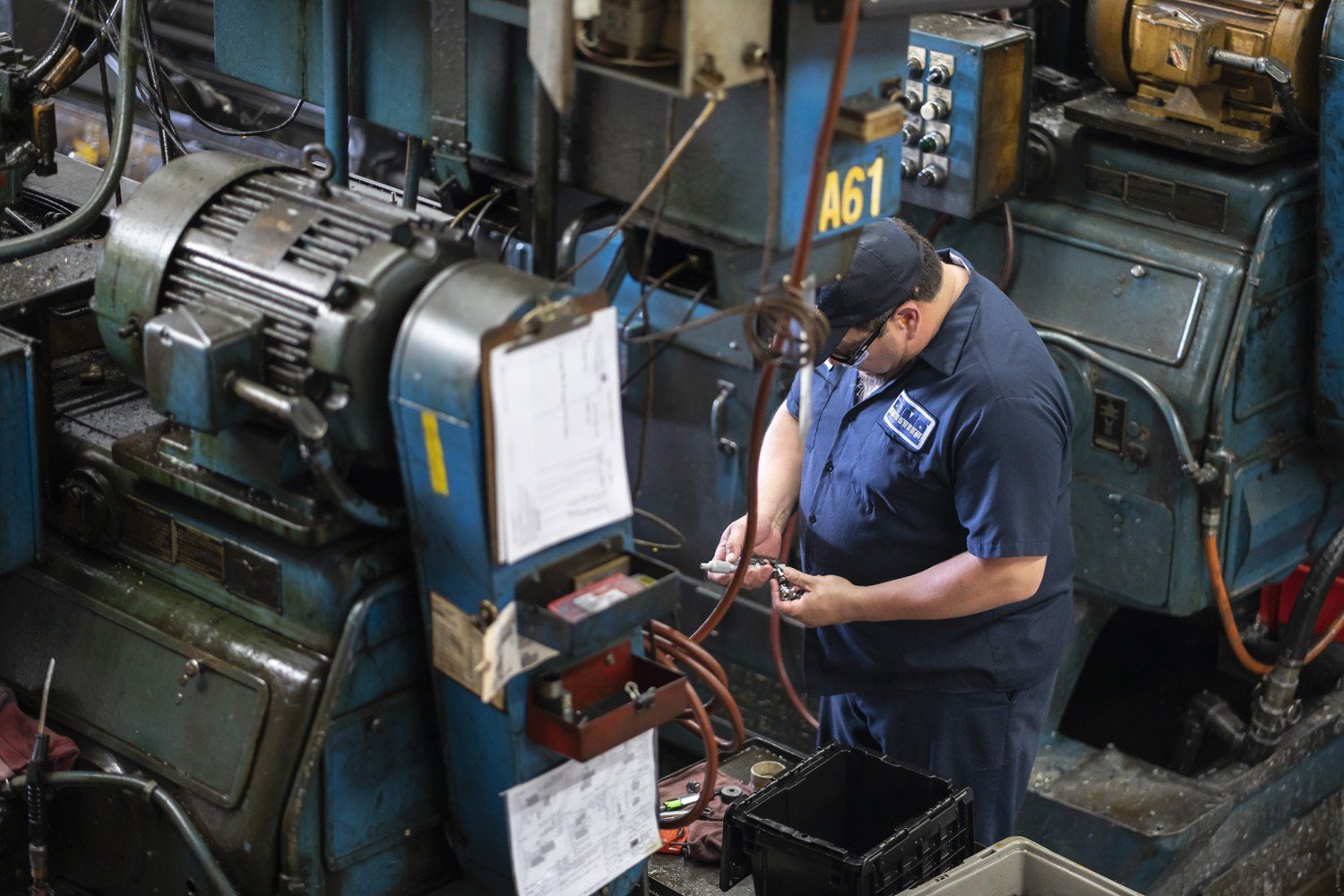 RIMA Manufacturing Company team member in blue uniform adjusts machinery