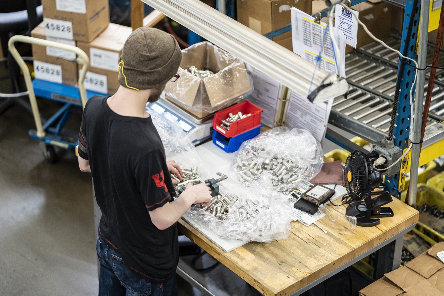 RIMA Manufacturing Company team member working at a workbench, sorting small metallic objects