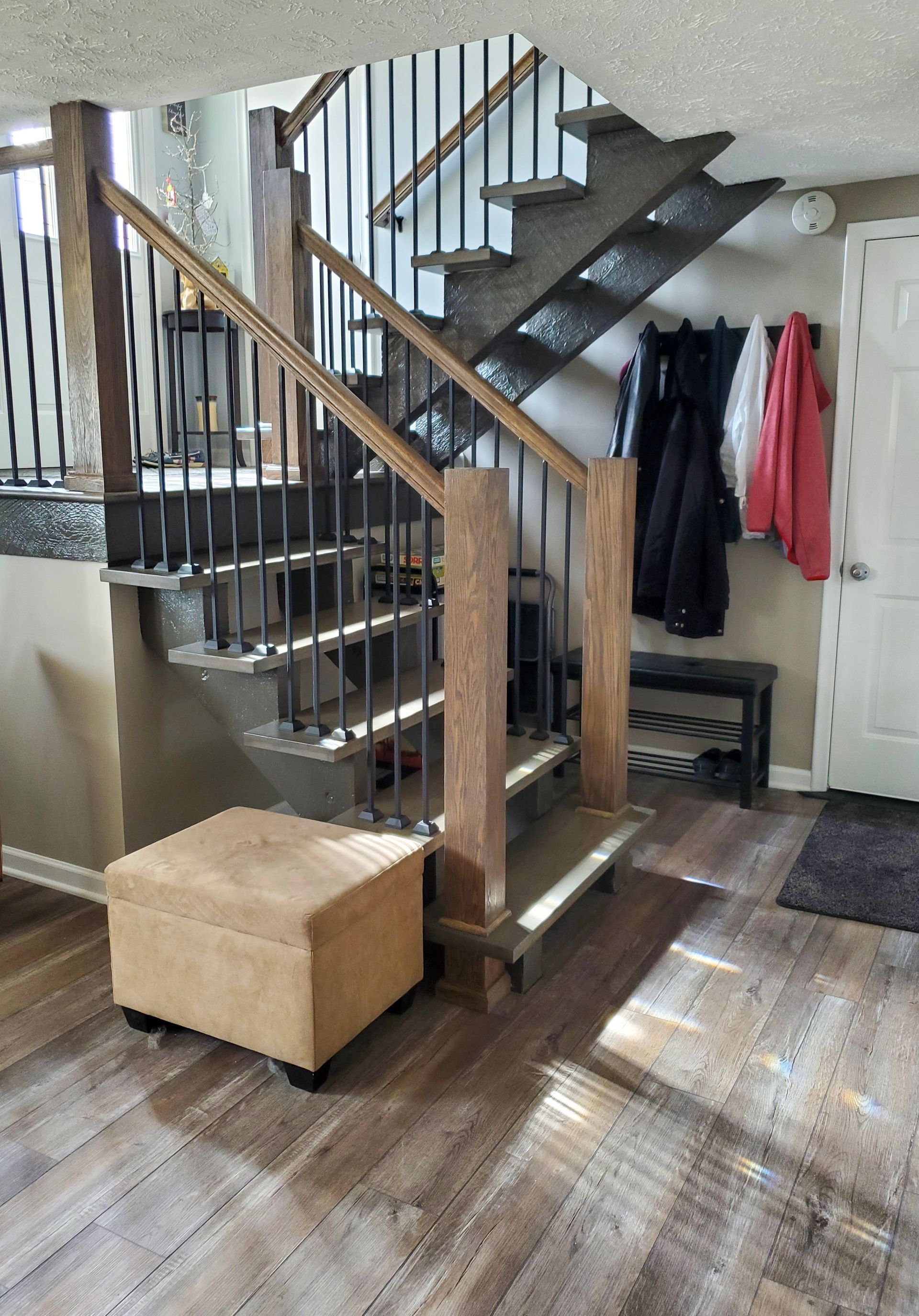 Staircase in the Middle of the Room With a Wooden Railing — Omaha, NE — Ohana Wood Floors Inc.