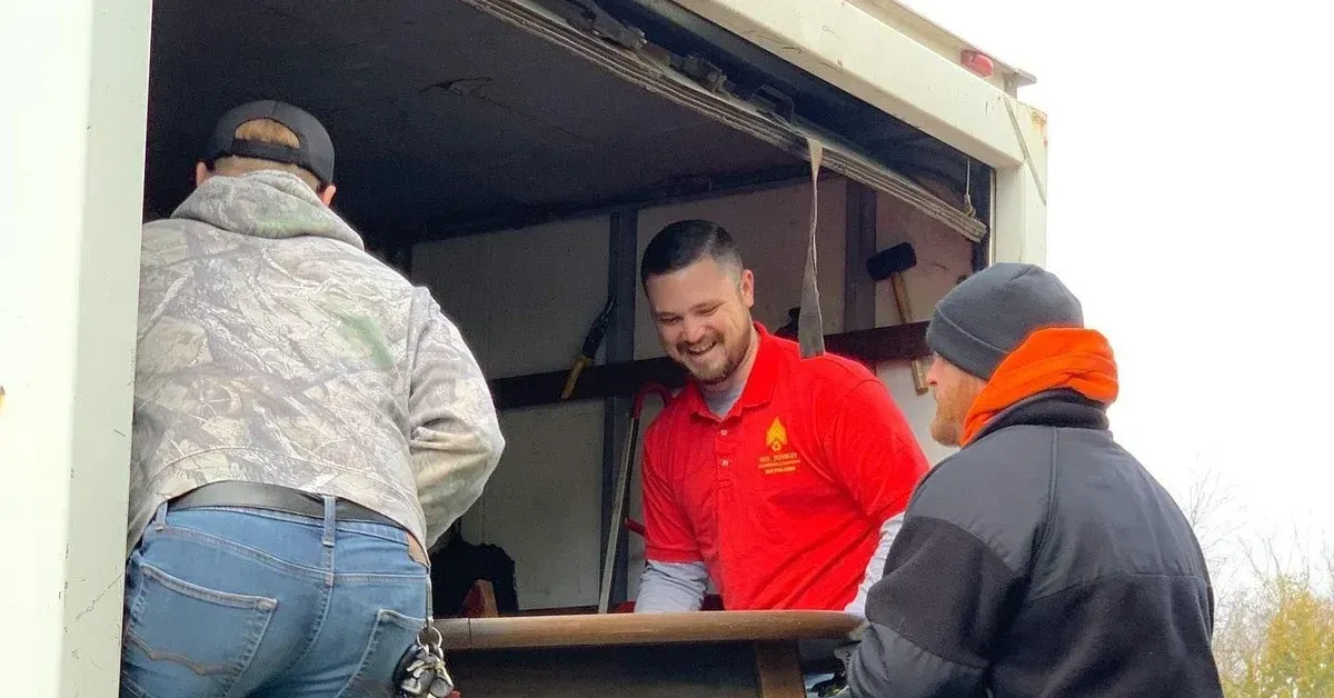 Sgt Junk-It crew loading a wooden table onto a truck during a junk removal job in Louisville, KY