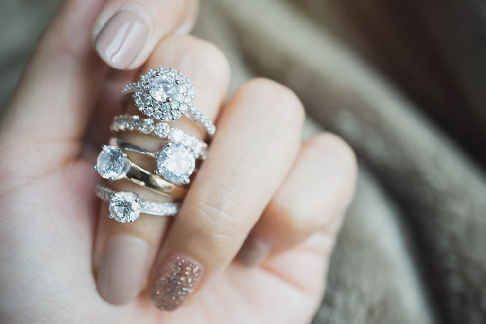 A woman is holding a stack of rings on her finger.