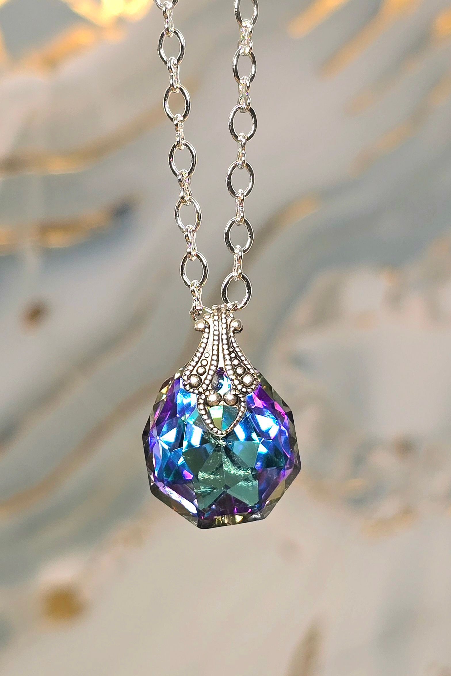 A necklace with a blue and purple pendant on a chain