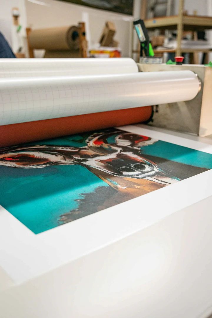 A picture of a dog is being printed on a machine.