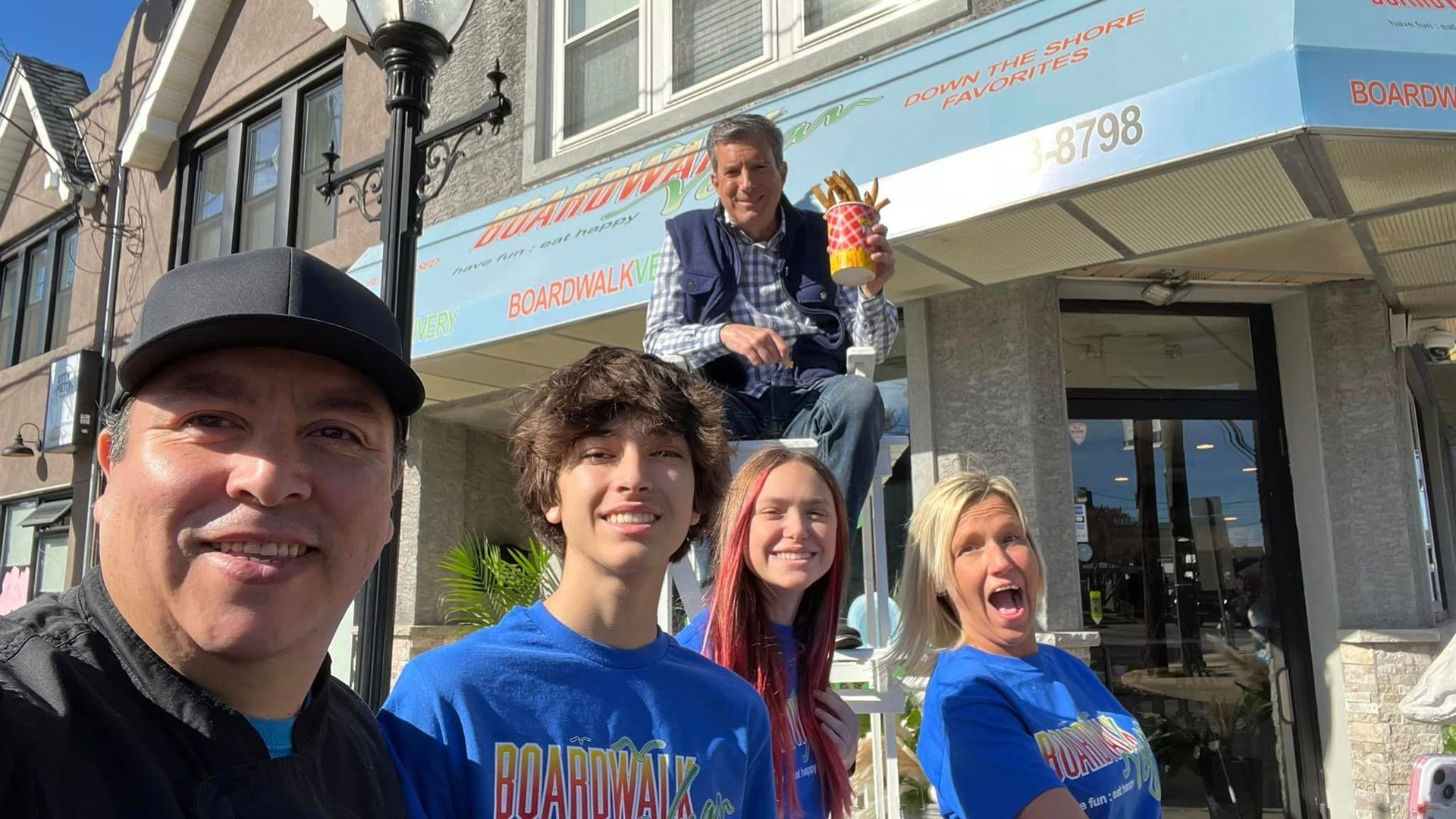 A group of people are posing for a picture in front of a building.