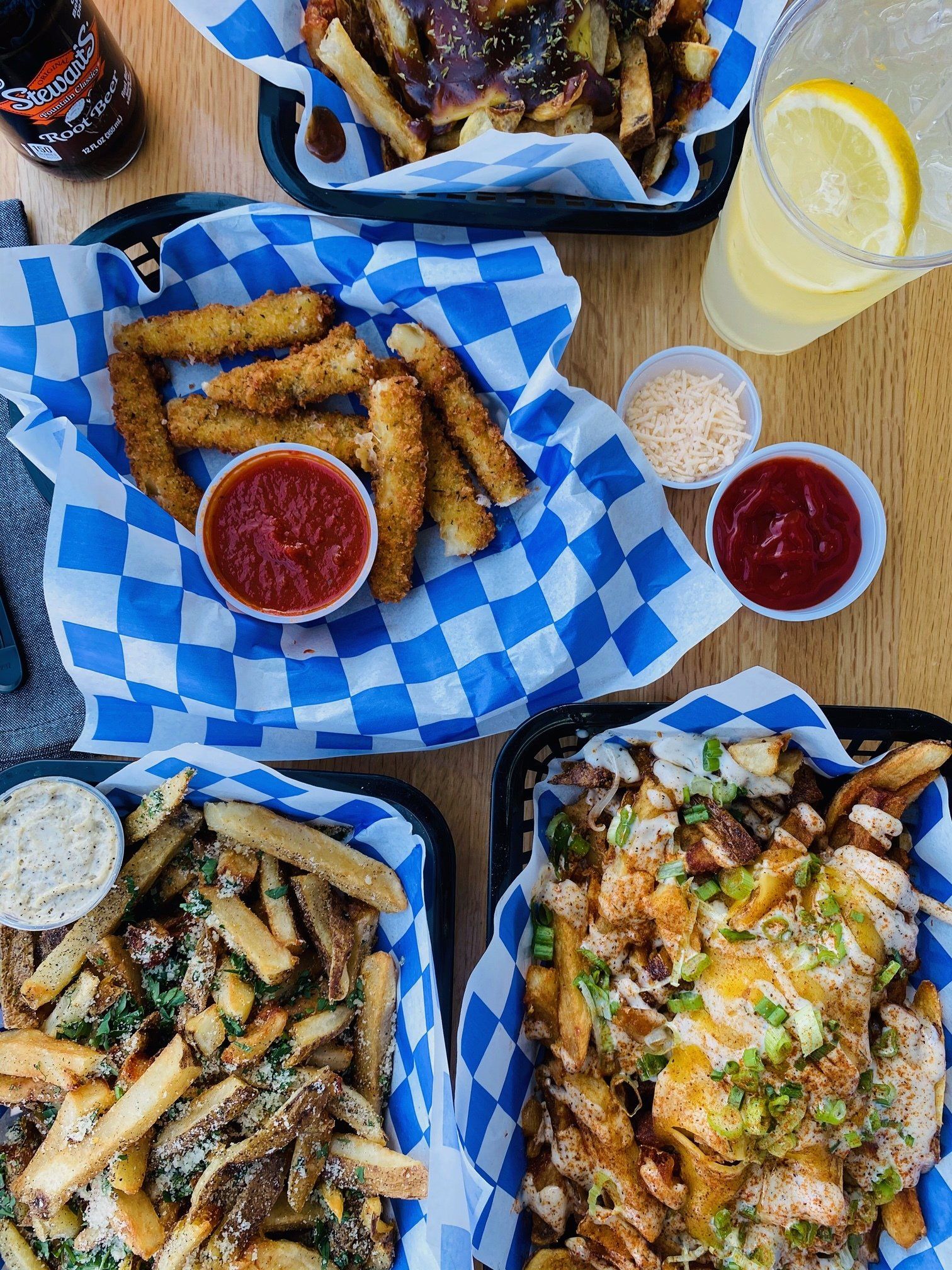 A table topped with a variety of french fries and mozzarella sticks.