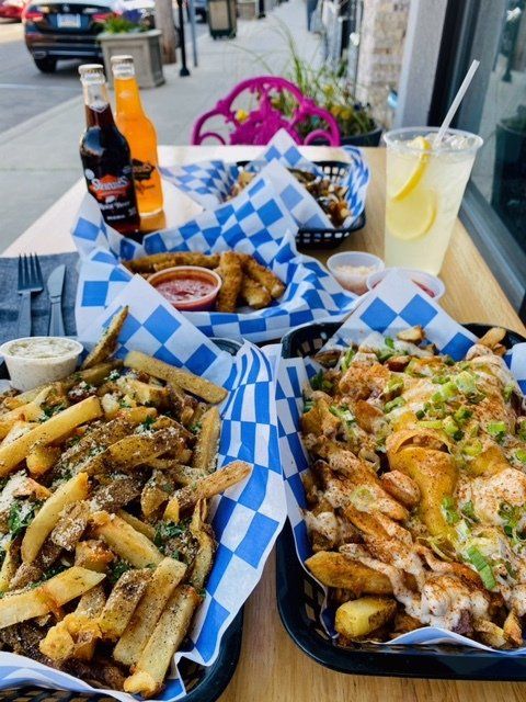Two baskets of french fries are sitting on a table