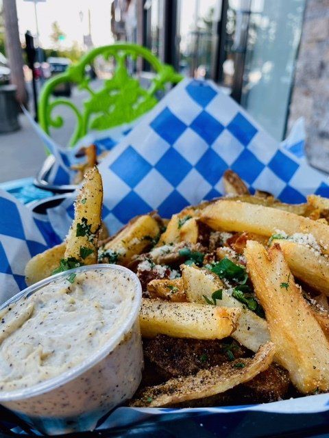 A basket of french fries with a side of dipping sauce