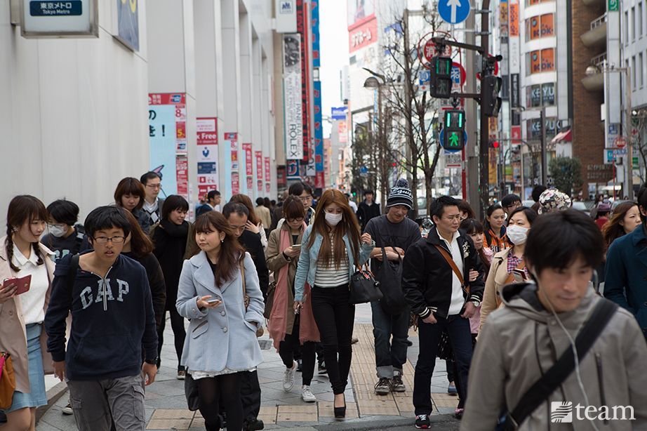 Japanese people walk on a busy sidewalk