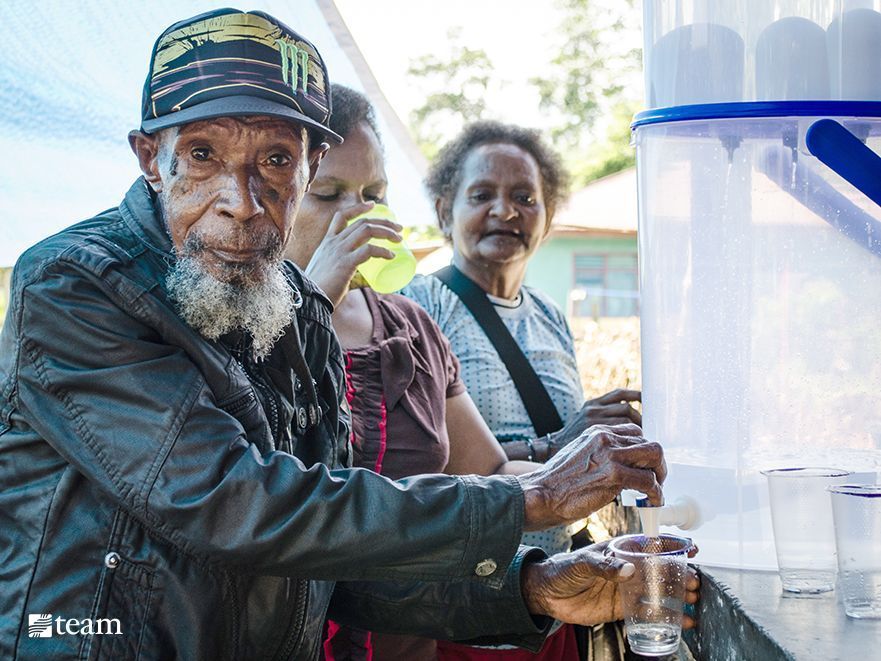 Papuan man getting clean drinking water.