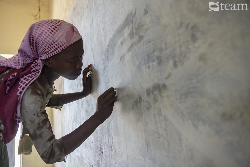 A woman in Chad is learning to write. 