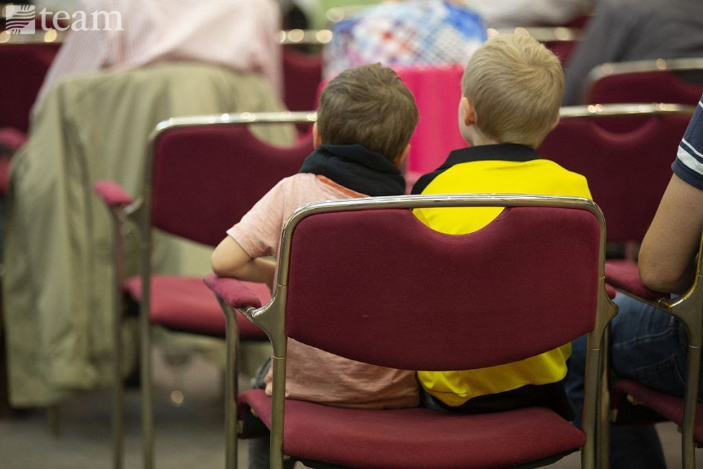 Two kids sit together in church