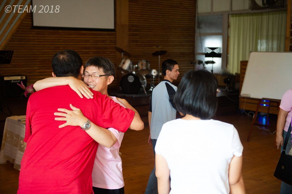 A church member embraces his pastor in a hug.
