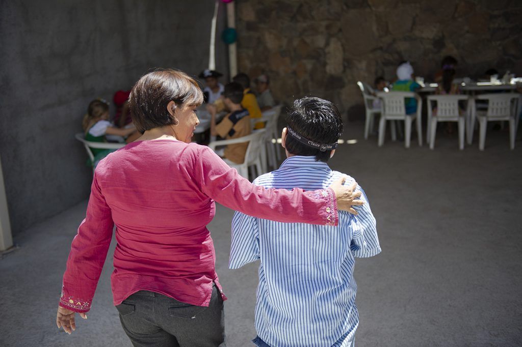 A woman in Mexico puts her arm around her son.