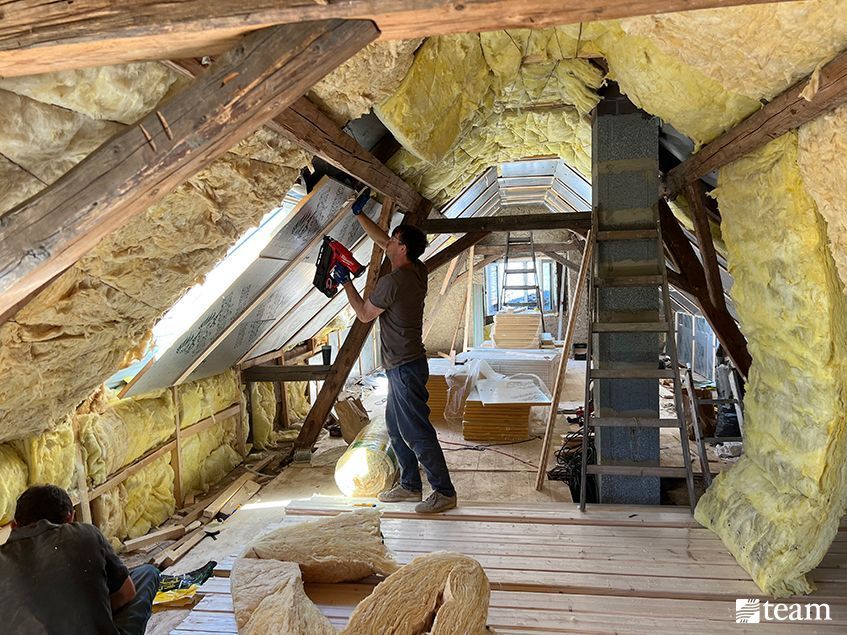 Man adding insulation to the attic.
