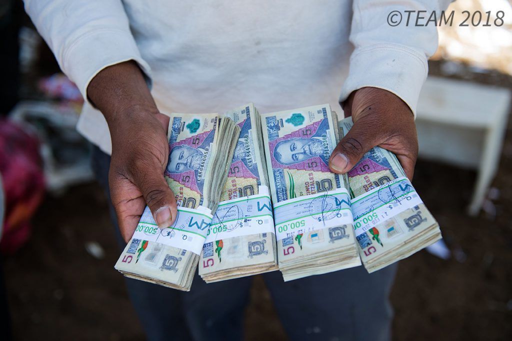 A man in Guatemala holds Guatemalan cash.