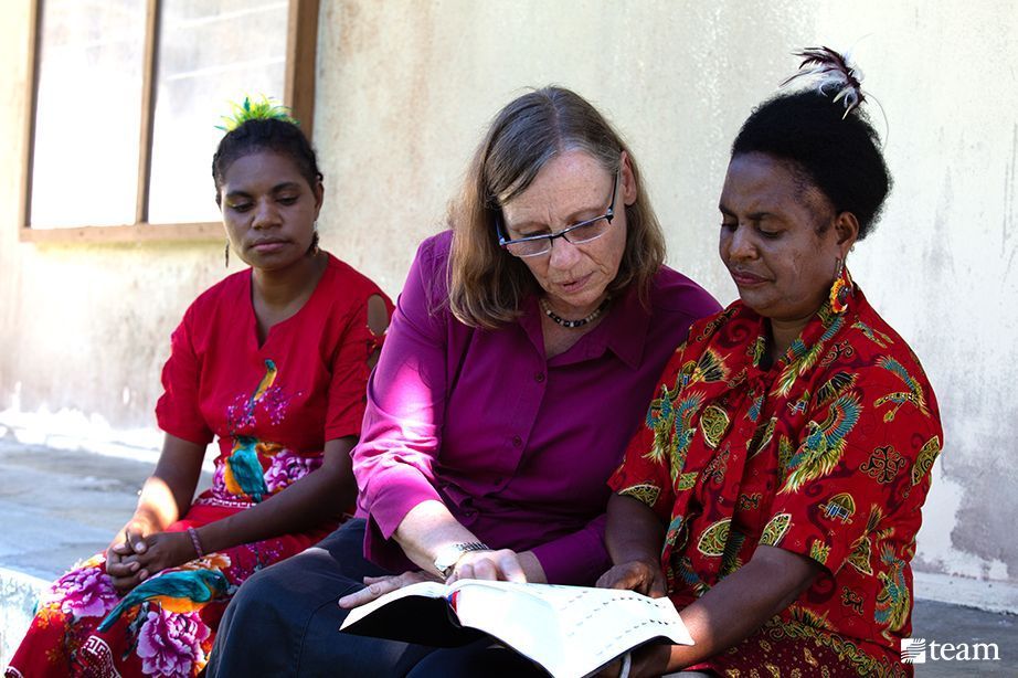 Three women reading the Bible.