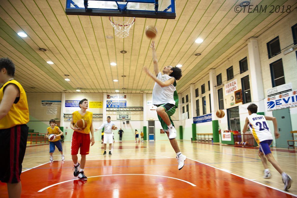 A participant at basketball camp jumps up to make a basket