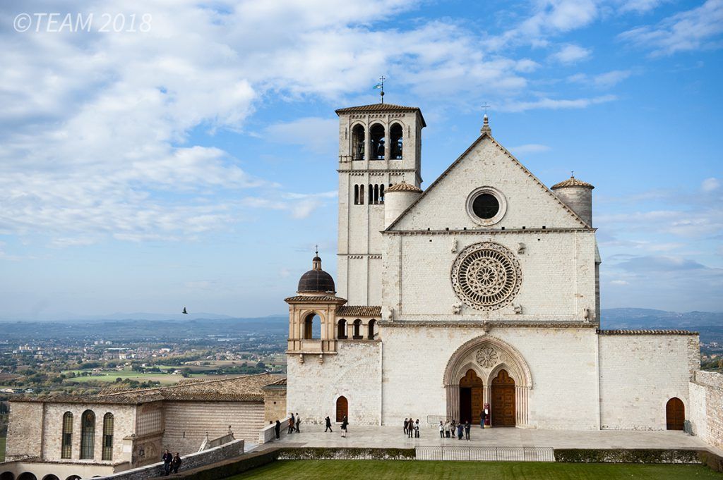A large, beautiful Cathedral in Italy sits overlooking the city below.
