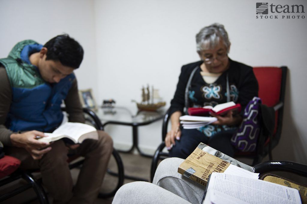 A group of people in Mexico sit and read their Bibles together.