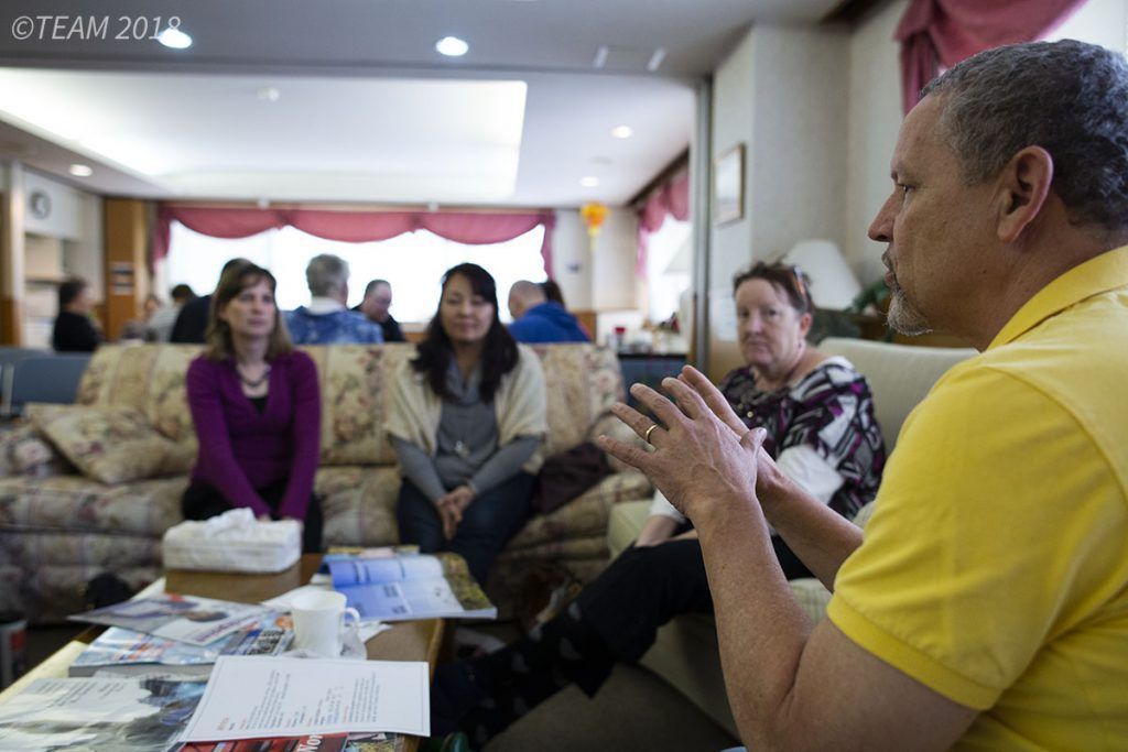 A group of missionaries talk with each other, which can be helpful in language learning.