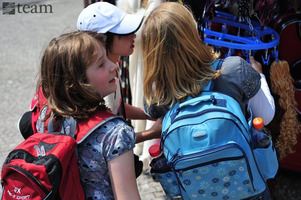Two girls with backpacks have a conversation. Missionary kids on home assignment travel a lot.