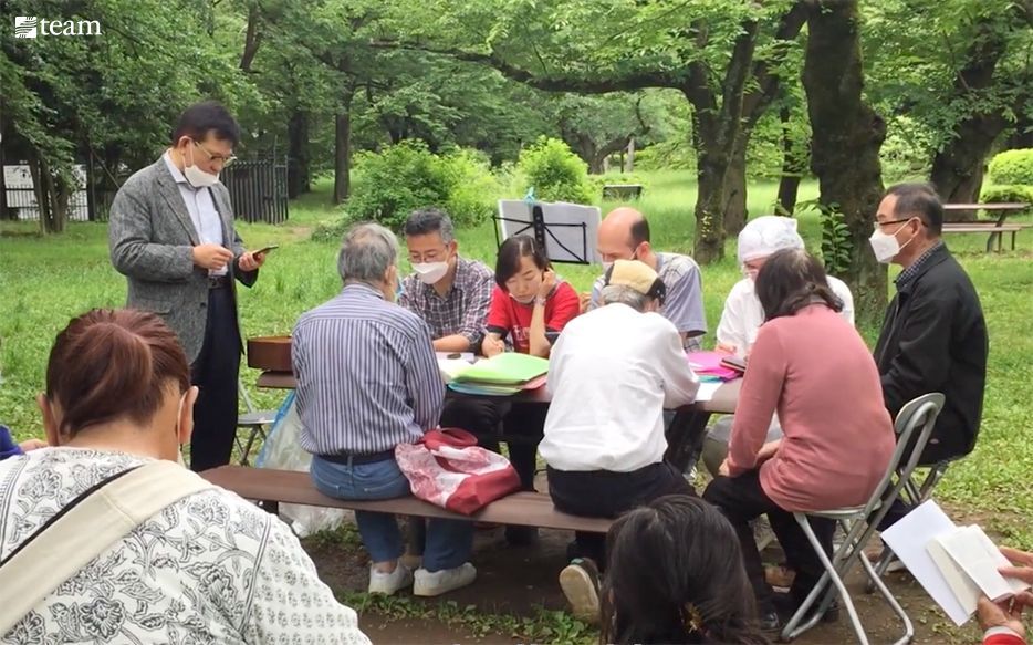People sharing food at a picnic table.