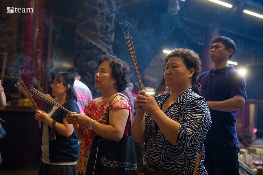 Group of people burning incense in the temple