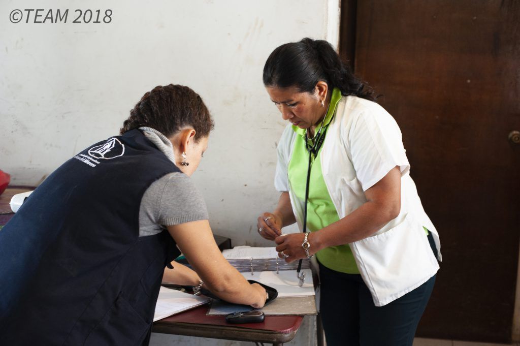 A missionary serving as a nurse reads the chart of one of her patients.