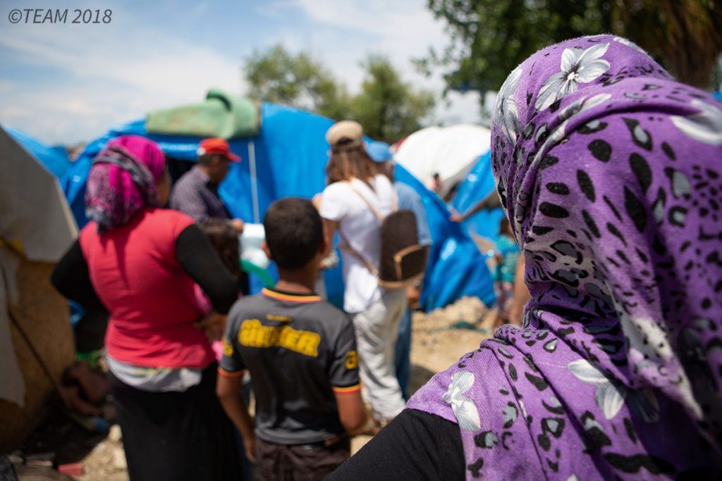 A group of refugee women and children stand together at the refugee camp