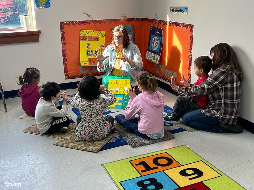 Teacher with children in the floor.