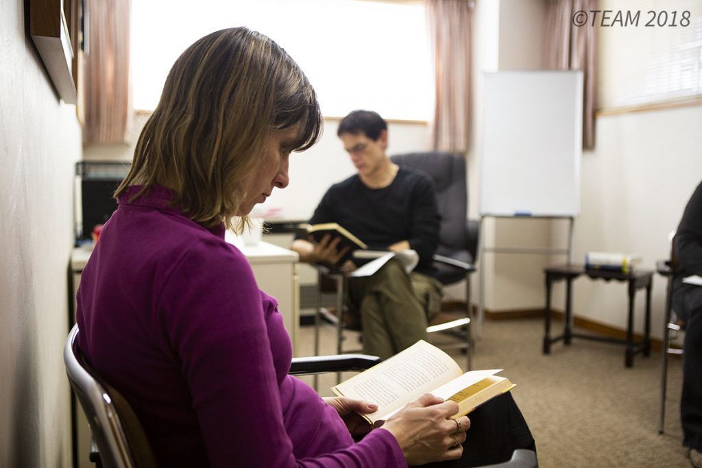 A woman sits and reads her Bible