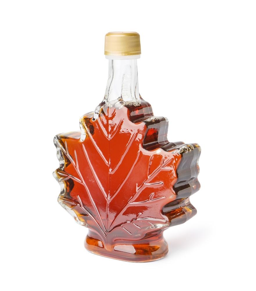 A bottle of maple syrup in the shape of a maple leaf.