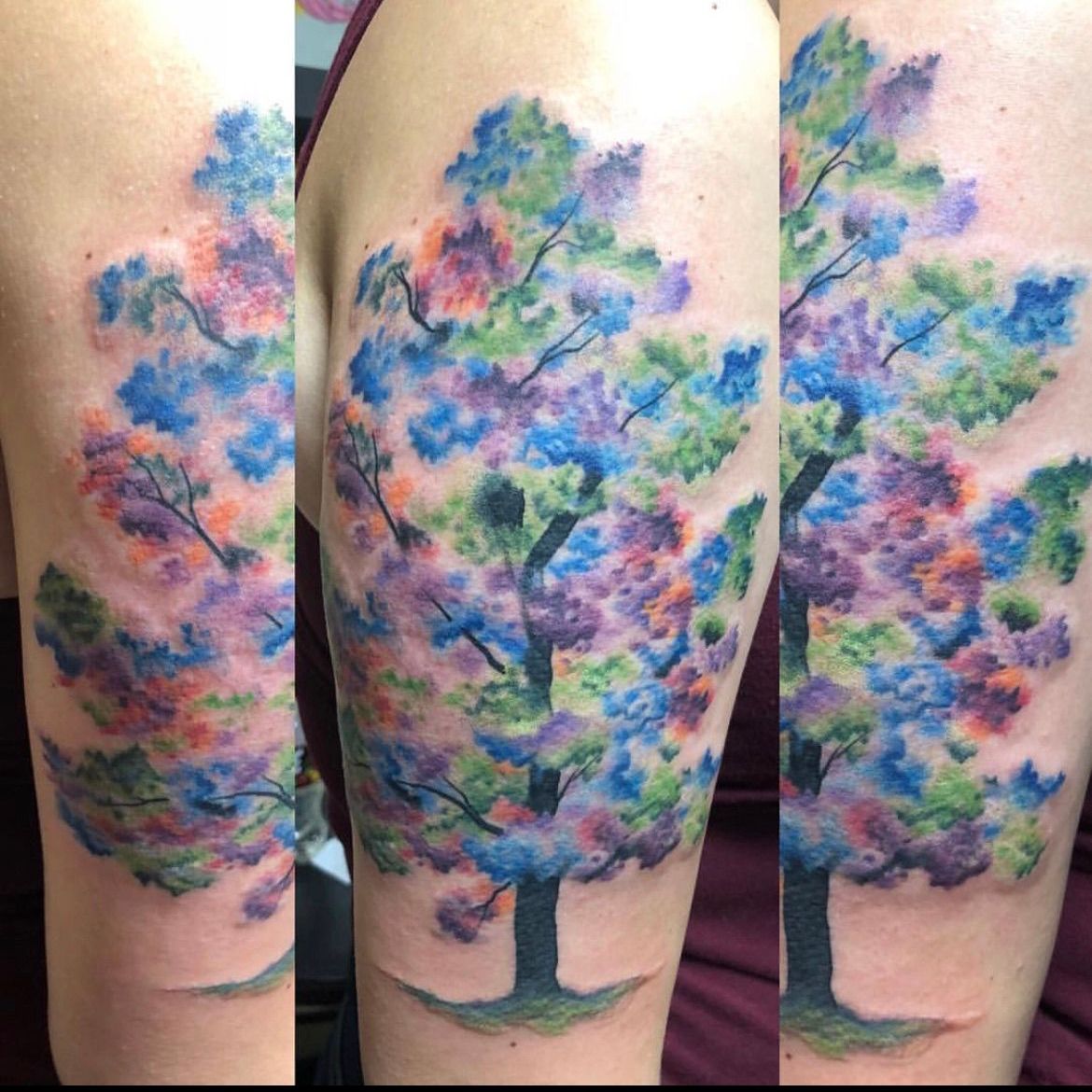 A tattoo of a tree with purple flowers and green leaves