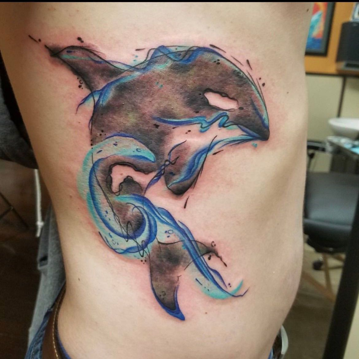 A man has a tattoo of a killer whale on his side