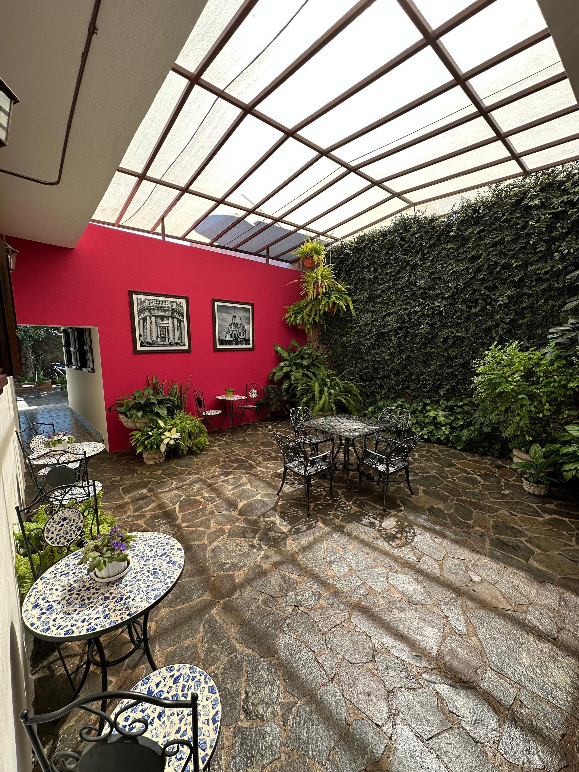 Patio interior techado con mesas y plantas decorativas en hotel
