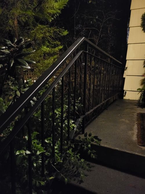 A black railing on a set of stairs at night