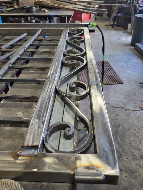 A piece of wrought iron is sitting on a table in a workshop.