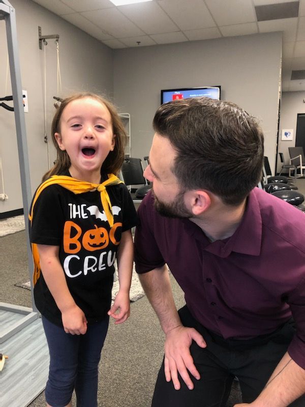 a little girl wearing a shirt that says the boo crew with chiropractor dr. nic