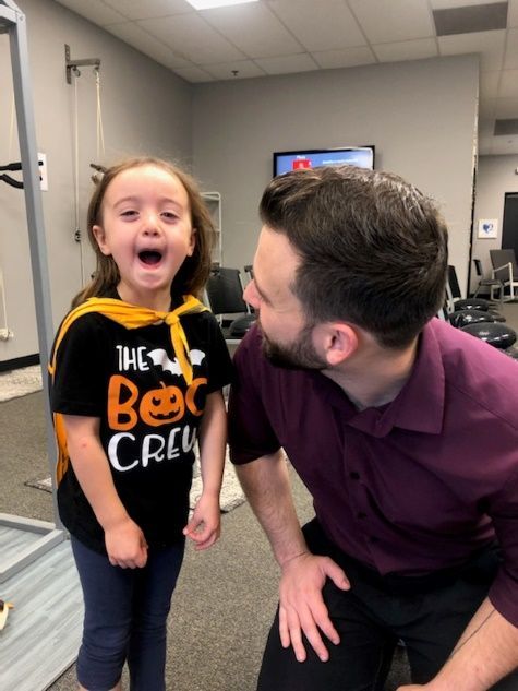 a little girl wearing a shirt that says the boo crew with chiropractor dr. nic