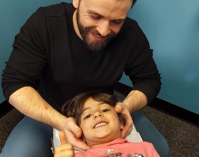 a Chiropractor is giving a little girl an adjustment